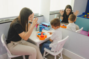 Psicóloga brincando com criança em sessão de psicologia infantil