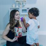 Fonoaudióloga brincando com criança pequena durante sessão de fonoaudiologia infantil